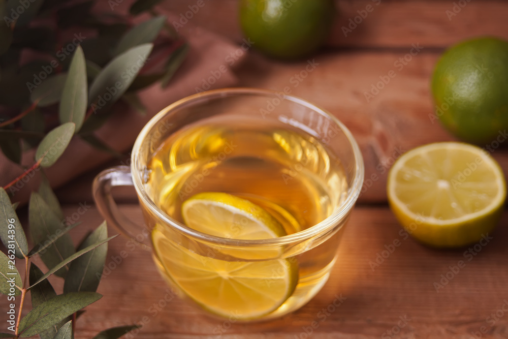 Cup of hot green tea with lime on the old wooden table Cup of hot green tea with lime on the old wooden table