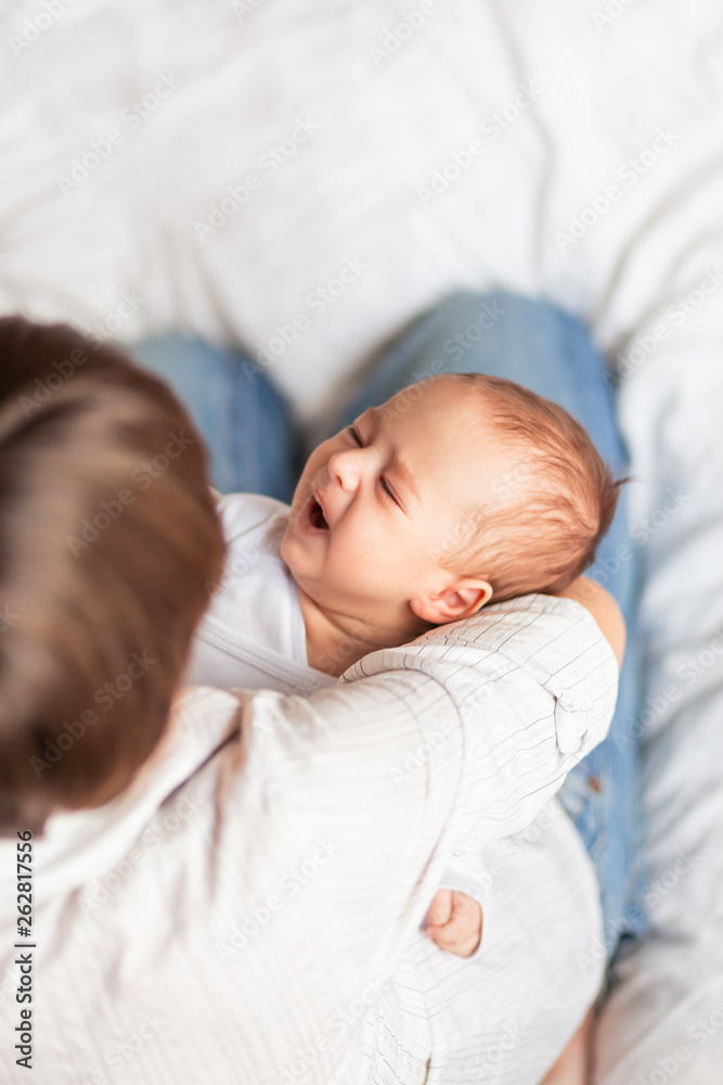 Woman holding a crying child. Mother comforts her little son or daughter. Woman holding a crying child. Mother comforts her little son or daughter.