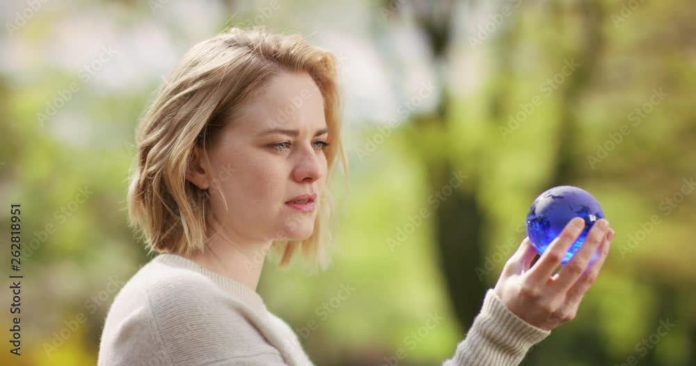 Beautiful woman holding a blue globe made out of glass Beautiful woman holding a blue globe made out of glass
