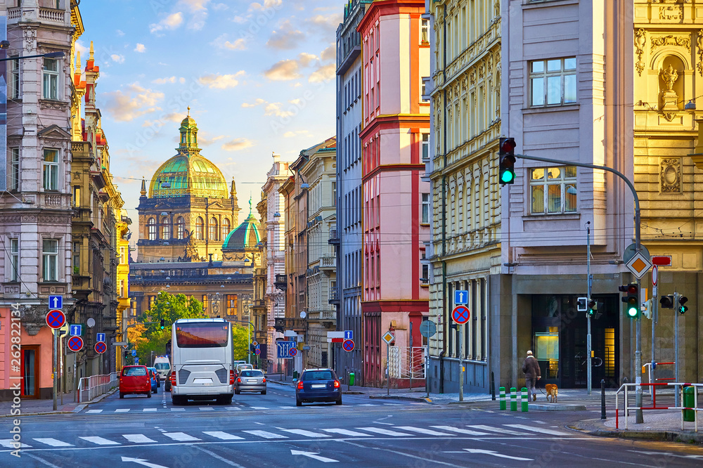 Obraz premium Street in Prague, Czech Republic. Cityscape with road and view at dome of national museum building. Transport and bus at crossroad. Dawn early morning in centre of city.