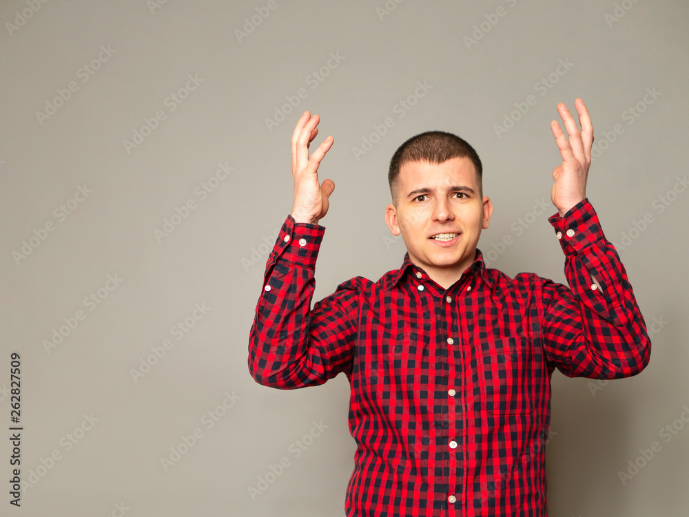 Emotional outraged man gestures angrily, being irritated, can`t concentrate. Crazy shaven male model gestures and shakes palms angrily. Stressed expression. Concept for work or business. Wear trendy