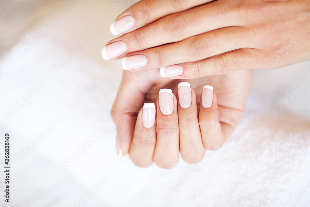New manicure. Side view of the process of manicure in salon. Professional manicurist provides a service to the client New manicure. Side view of the process of manicure in salon. Professional manicurist provides a service to the client