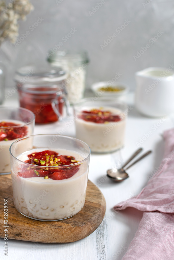 Healthy vegan dairy free dessert - tapioca pearls pudding with coconut milk and strawberry chia jam close up, served in glass jar Healthy vegan dairy free dessert - tapioca pearls pudding with coconut milk and strawberry chia jam close up, served in glass jar