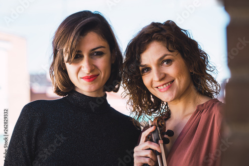Two women musician smiling outdoors