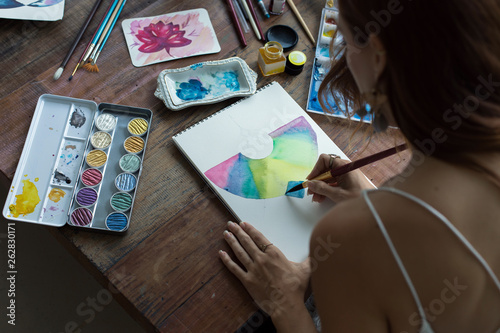 Latin artist painting with watercolor in her studio photo