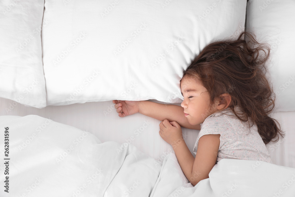 Cute little girl sleeping in bed, view from above. Space for text Cute little girl sleeping in bed, view from above. Space for text