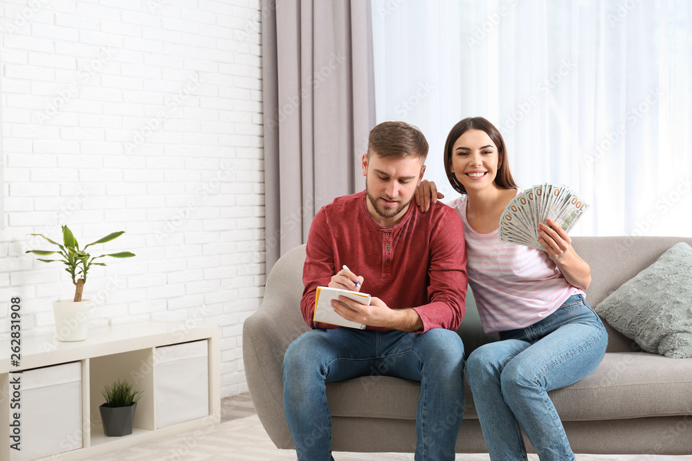 Obraz premium Beautiful young couple with money at home