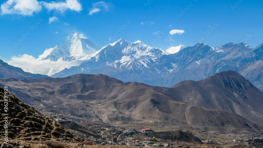 Annapurna Circuit Trek, Nepal. Clear sky above the peak. Picturesque landscape, Way to Upper Pisang, with small village on the bottom of the valley. White Himalayas mountain peaks