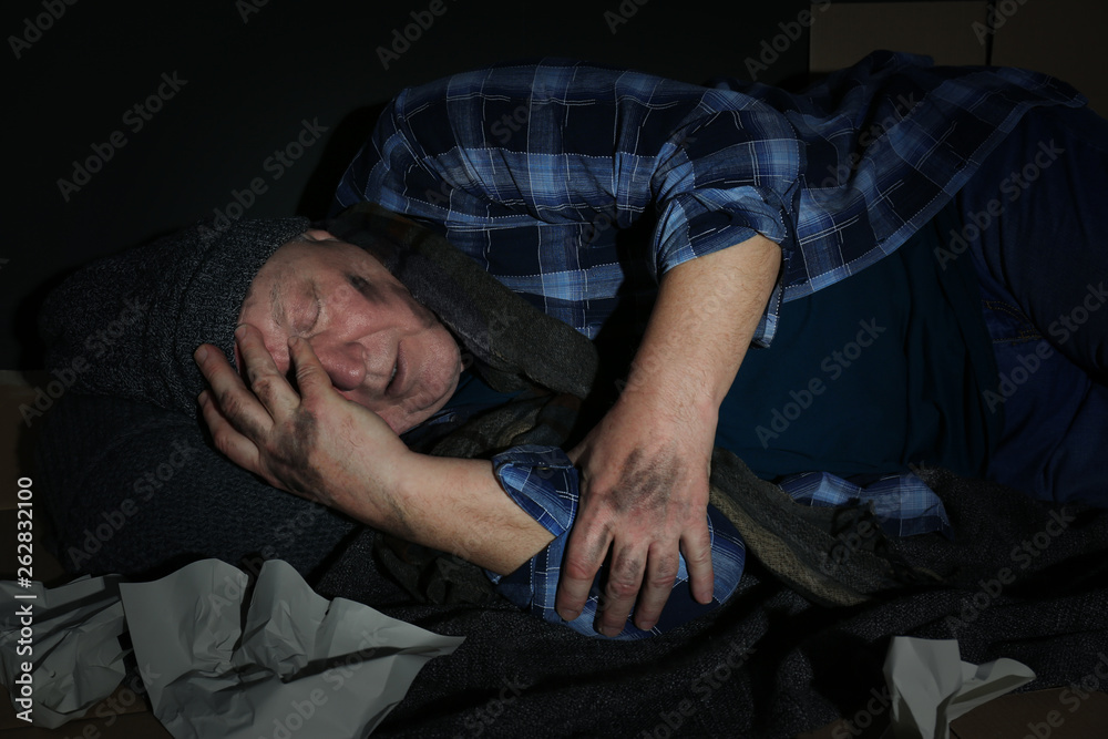 Poor senior man sleeping among garbage on floor Poor senior man sleeping among garbage on floor