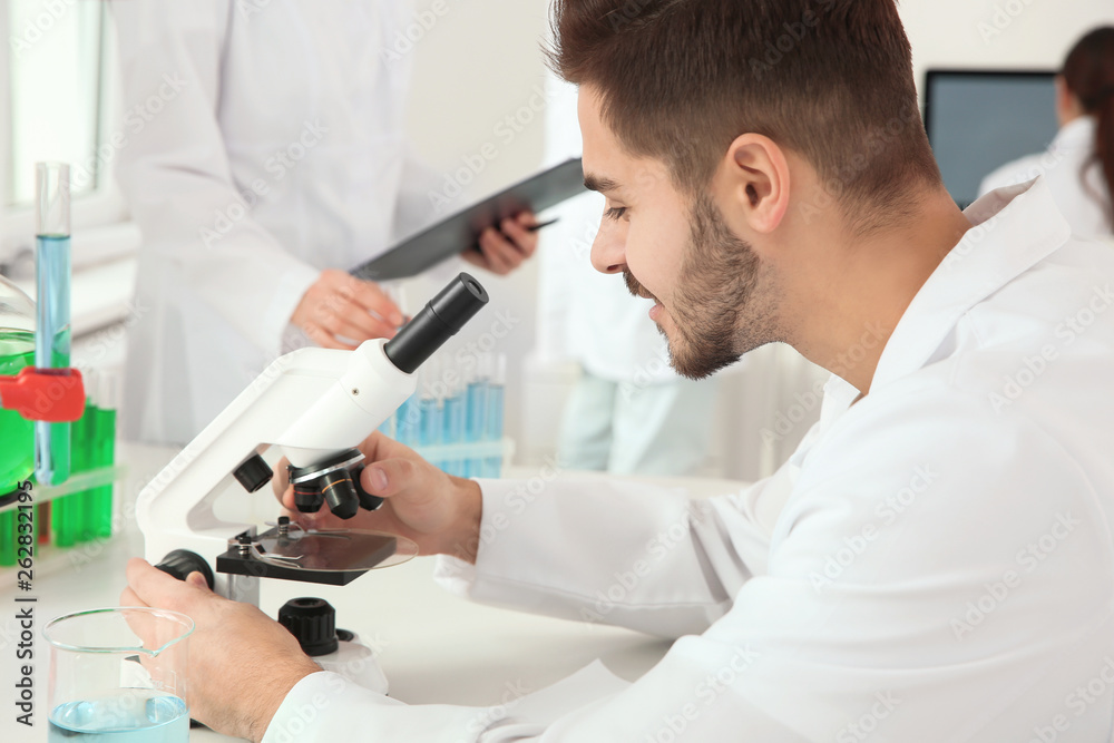 Medical student working with microscope in modern scientific laboratory Medical student working with microscope in modern scientific laboratory