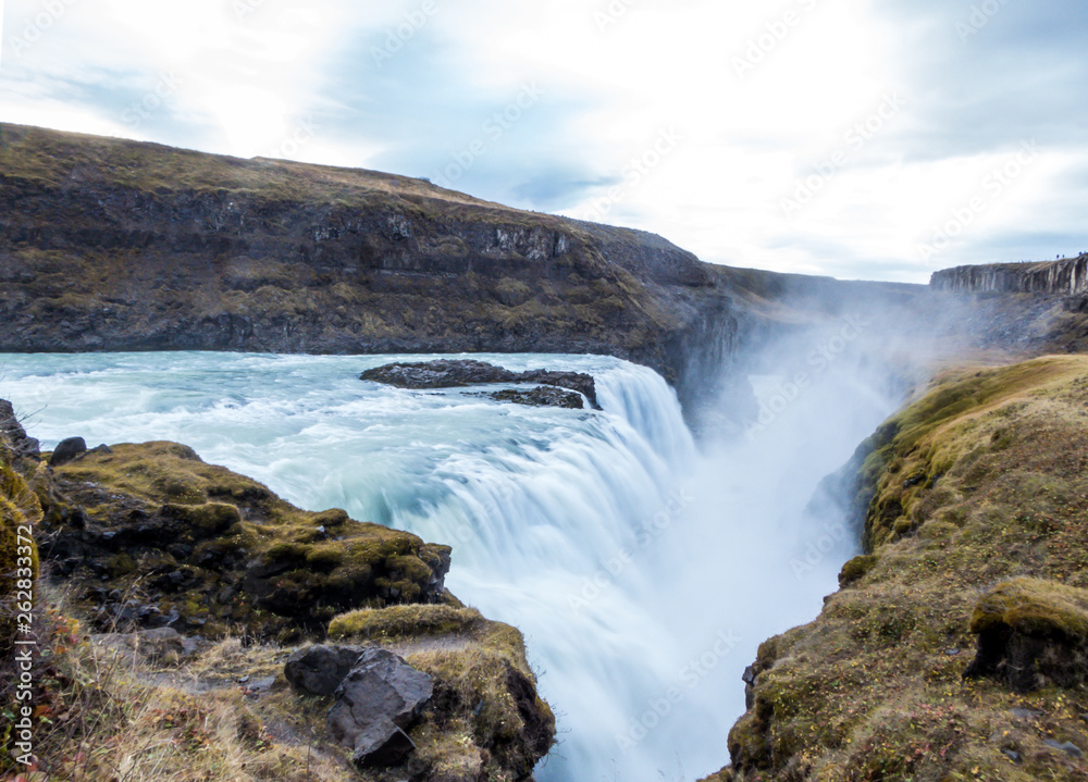 A mighty waterfall, falling into a gorge, spreading on a vast distance. Bottom of the waterfall is not visible. Gullfoss waterfall located in the canyon of the Hvítá river in southwest Iceland