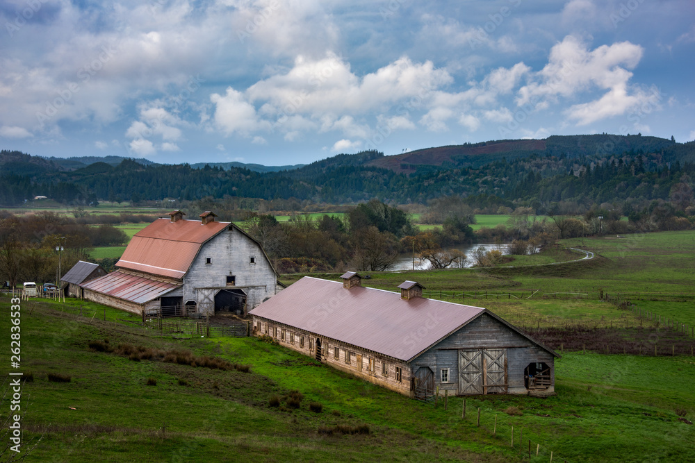 country barns in farmland with river and beautiful sky