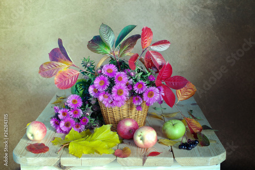 Bouquet with pink and blue santarini , yellow leaves on a wooden table