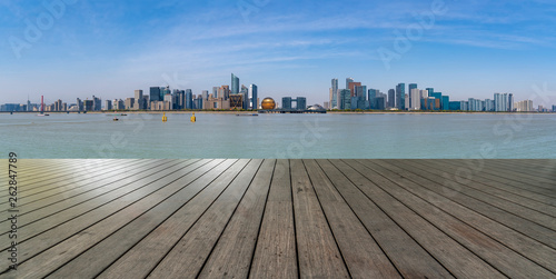 Empty square tiles and skyline of urban buildings..