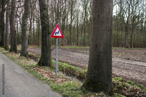 Traffic sign S-bend right with trees and a forest in the Netherlands, Europe