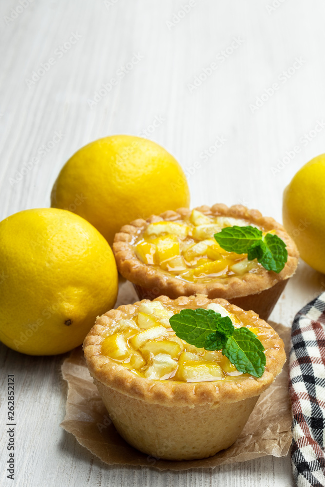Egg custard tarts with jellied lemon on white wooden table Egg custard tarts with jellied lemon on white wooden table