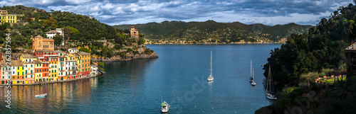Colorful buildings in the raw, sailboats on sea and panoramic scenic view of village Portofino in Liguria region in Italy
