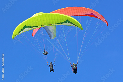 Paragliders in a blue sky