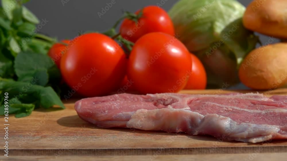 Veal steak falls on a wooden cutting board.. Still life of meat, herbs, spices and vegetables Veal steak falls on a wooden cutting board.. Still life of meat, herbs, spices and vegetables