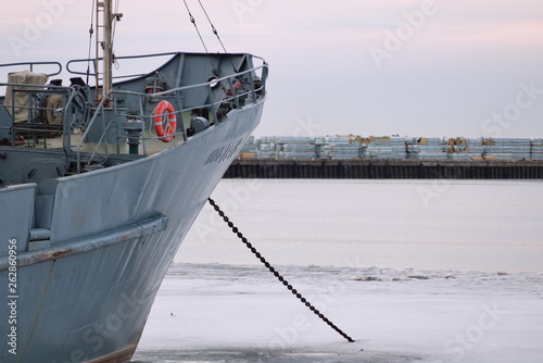 Standing on the prow of a ship anchored in the Bay in winter