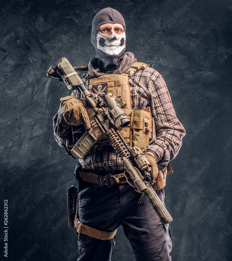 Private security service contractor wearing a balaclava skull holding an assault. Private security service contractor wearing a balaclava skull holding an assault.