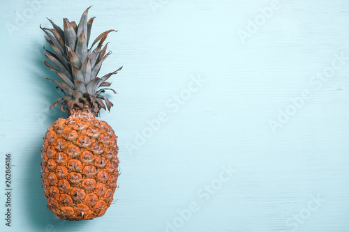 Ripe pineapple left side on a blue wooden table