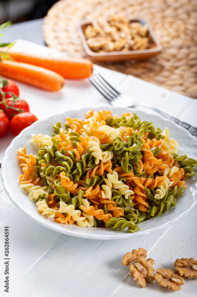 Multicolored pasta with vegetable on wooden background ve vegetables Multicolored pasta with vegetable on wooden background ve vegetables