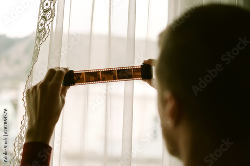 Young man looking at the film roll
