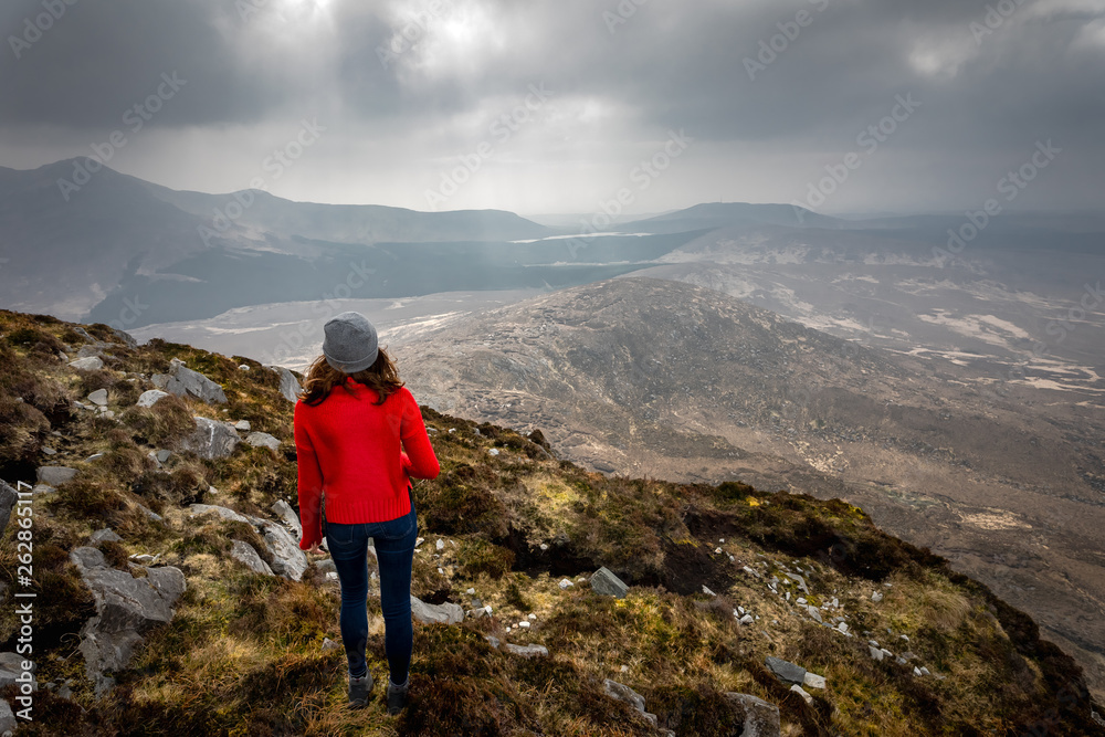 Obraz premium une jeune femme en tenue de trekking au sommet d'une montagne 