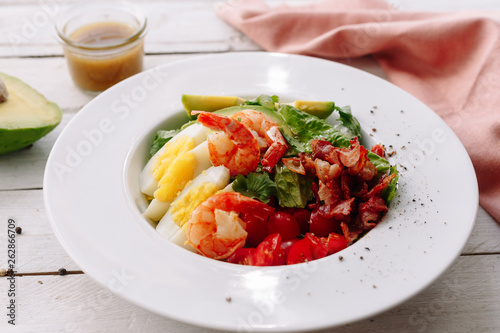 King prawns salad with egg, cherry, shrimp avocado and vegetables. Sauce. Dinner. Healthy food.