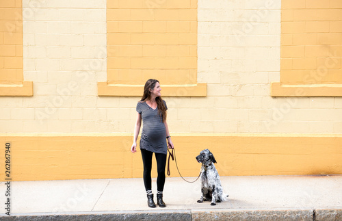 Pregnant Woman Walks her Dog in the City
