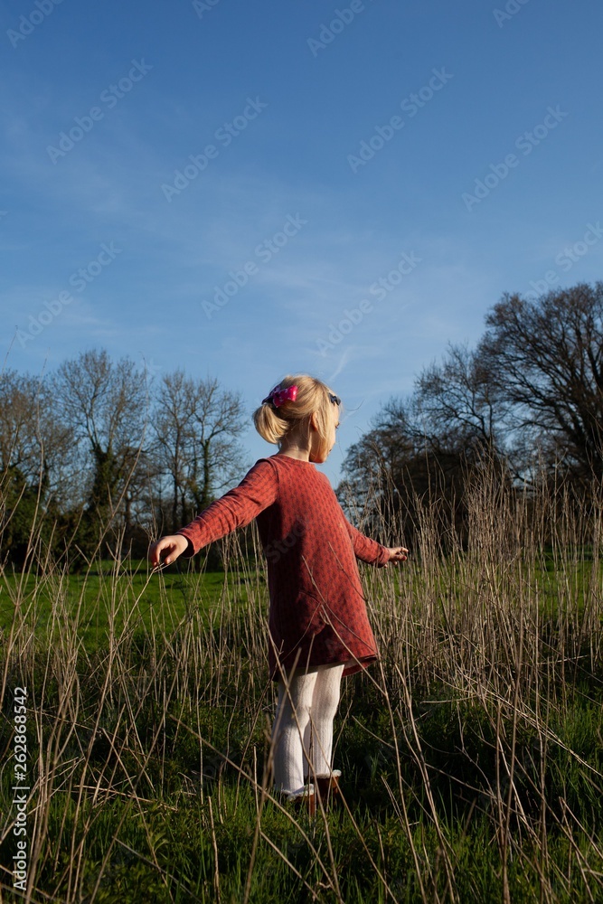 A young girl plays in the countryside. A young girl plays in the countryside.