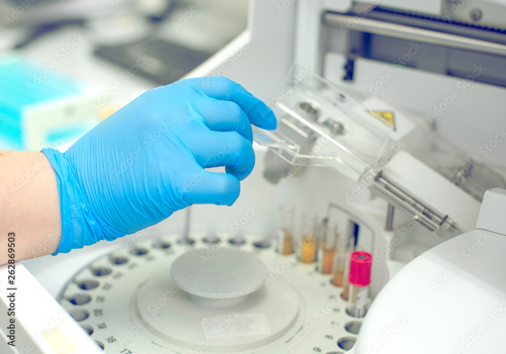 Woman working in a laboratory on a modern machine for blood testing. Doctor checks the blood of the patients. Blood research in a modern scientific workplace Woman working in a laboratory on a modern machine for blood testing. Doctor checks the blood of the patients. Blood research in a modern scientific workplace