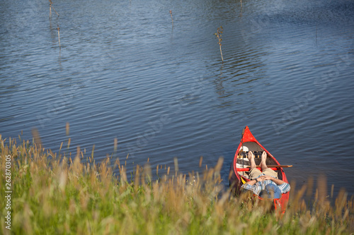 Stock photo of a man resting in a canoe on a summer day photo