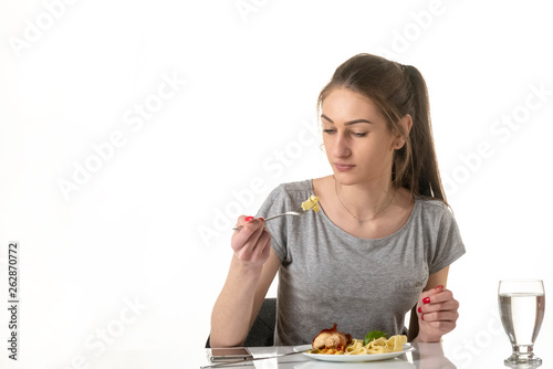 a young girl eats a meal in a restaurant
