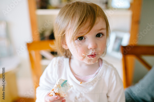 toddler eating cake and making a mess photo