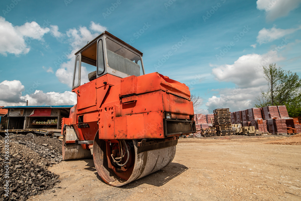 Heavy vibration red road roller compactor at the construction site Heavy vibration red road roller compactor at the construction site