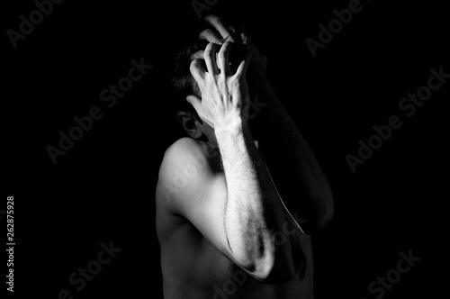 dramatic black and white photography  a man holding his head  in an emotional pose