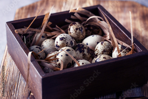 Quail eggs. Flat lay composition with small quail eggs on the natural wooden background. One broken egg with a bright yolk. photo