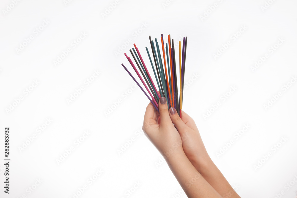 Hand and colorful incense isolated on white background