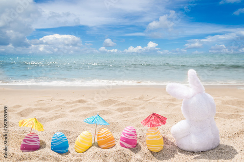 Beach Easter background with bunny and color eggs