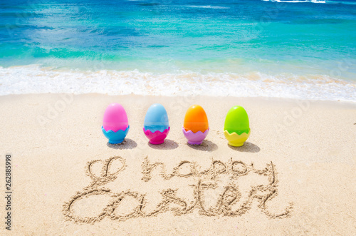 Happy easter background with color eggs on the beach