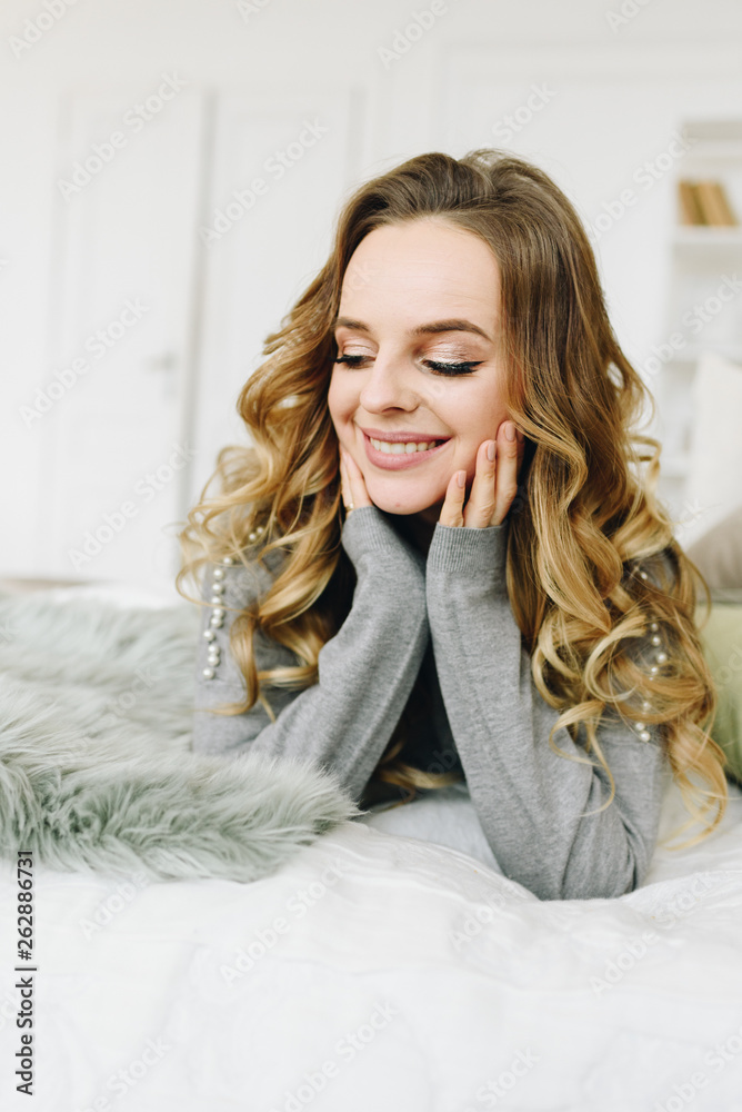 Beautiful young caucasian European woman lying on bed looking down Beautiful young caucasian European woman lying on bed looking down