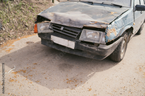 Car with damaged headlamp after collision. A close up of a broken car after a traffic accident. Crumpled side of a car as a result of a clash. 