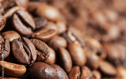Close up brown and black roasted coffee beans or grains background. Heap or stack of coffee concept