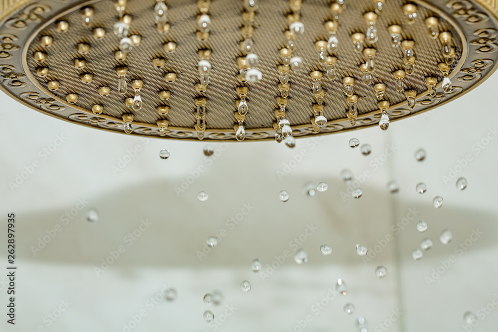 Golden shower head on wall with faience