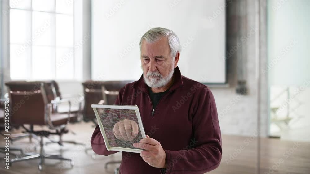 Adult caucasian male editing computer code on a futuristic touchpad screen Adult caucasian male editing computer code on a futuristic touchpad screen