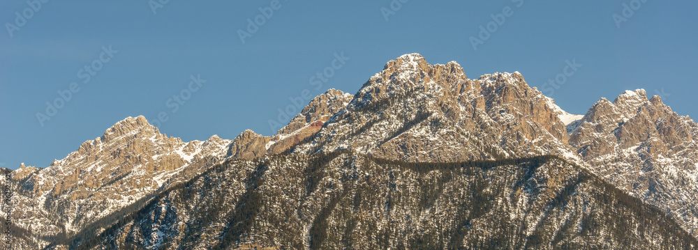 view of rocky mountains on a sunny spring day with clear blue sky.
