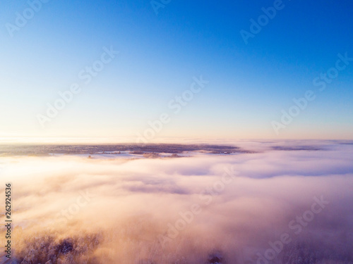 Aerial view clouds over forest during winter colors. Aerial view of forest and clouds. Coastline. Aerial drone view of the forest. Aerial top view cloudscape. Texture of clouds. © Aleksei