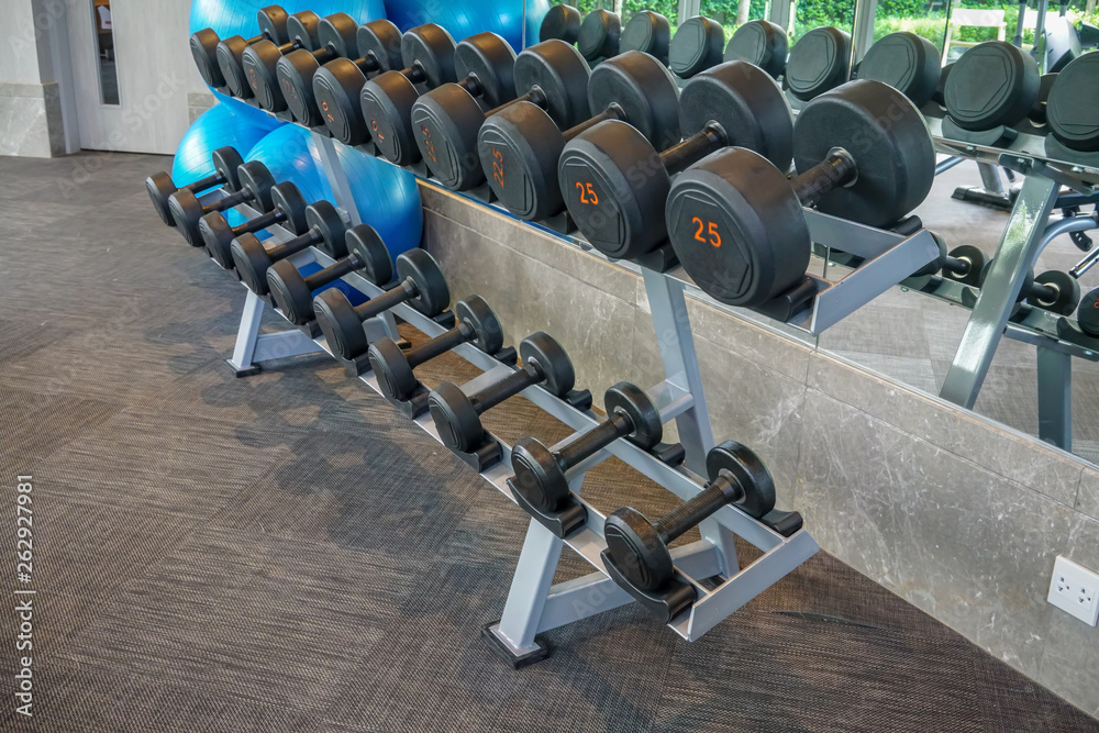 Dumbells set left on the racks in the gym.